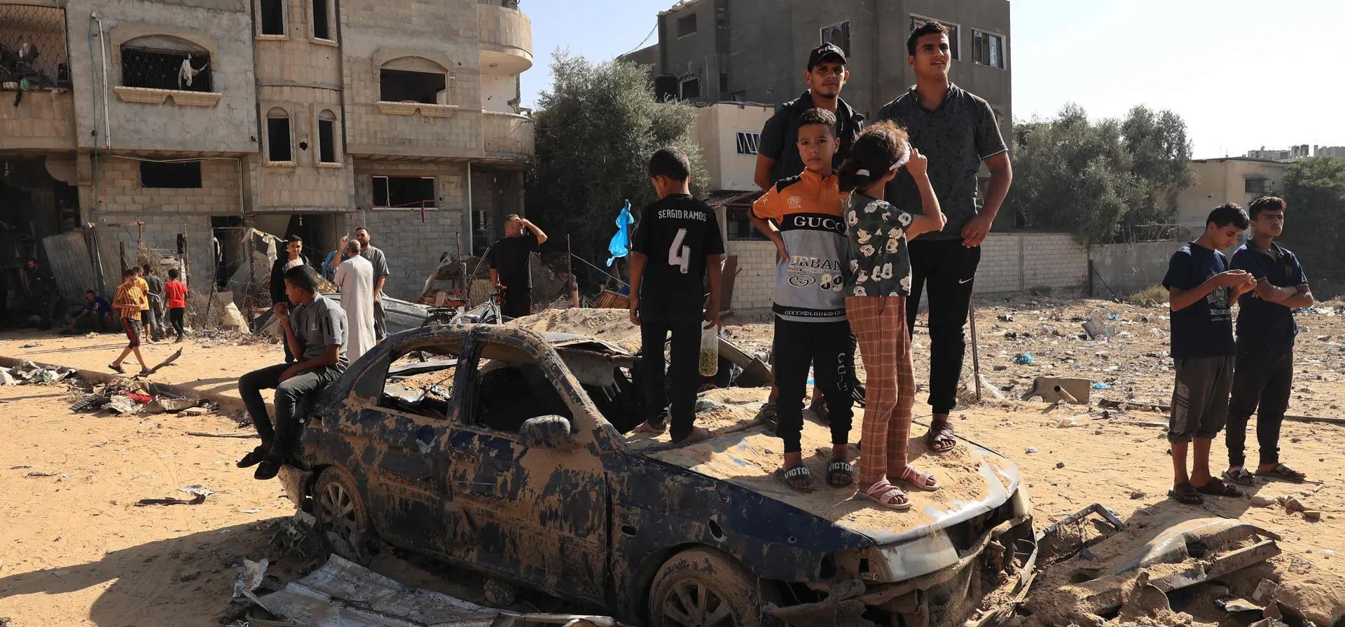La gente se para sobre un vehículo destruido mientras observa a los rescatistas buscar entre los escombros de un edificio después de un ataque israelí, Rafah, Franja de Gaza. Fotografía: Said Khatib/AFP/Getty Images La gente se para sobre un vehículo destruido mientras observa a los rescatistas buscar entre los escombros de un edificio después de un ataque israelí, Rafah, Franja de Gaza. Fotografía: Said Khatib/AFP/Getty Images