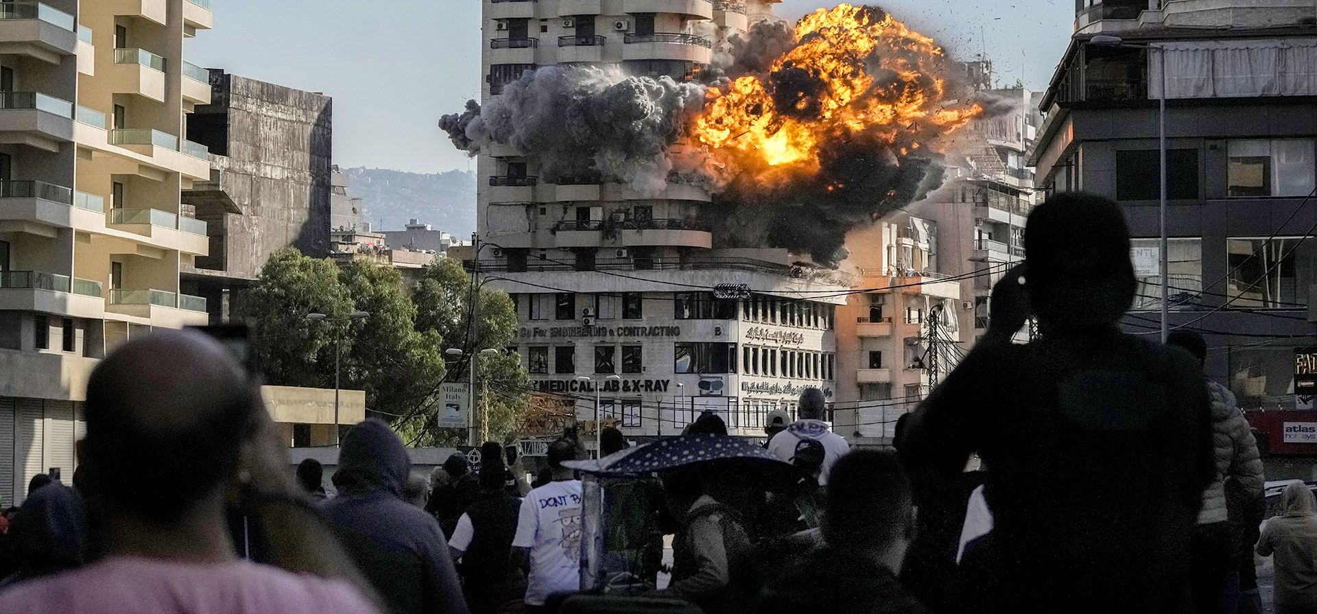 Ciudadanos libaneses contemplan el humo y las llamas que salen de un edificio alcanzado por un ataque aéreo israelí en Chiyah, en el suburbio sur de Beirut, Líbano, el viernes 22 de noviembre de 2024. (Foto AP/Bilal Hussein)