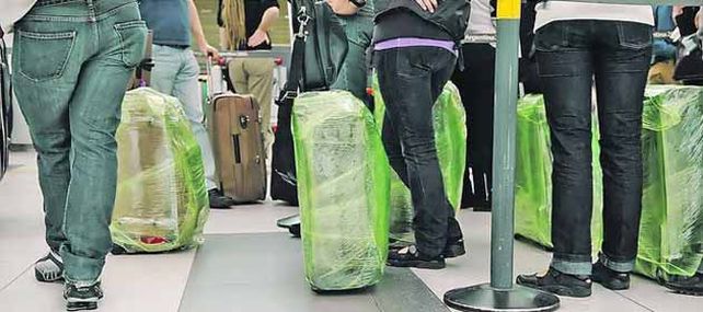 Numerosos pasajeros de Ezeiza recurren a forrar su valijas para evitar robos.