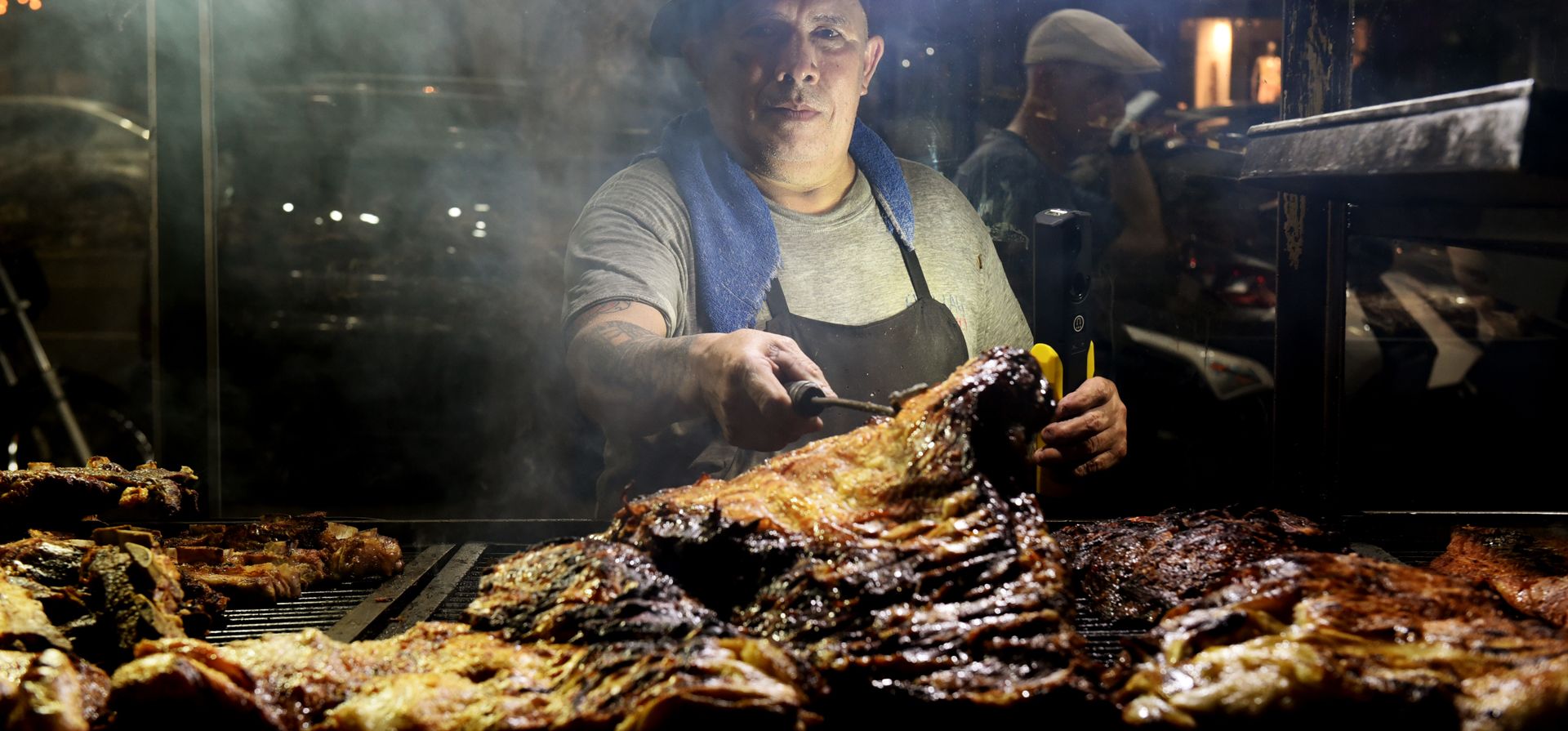 Vicente, asador parrillero de una reconocida rotisería ubicada en Pellegrini y Roca trabaja a centímetros del fuego en una jornada agobiante en la ciudad.