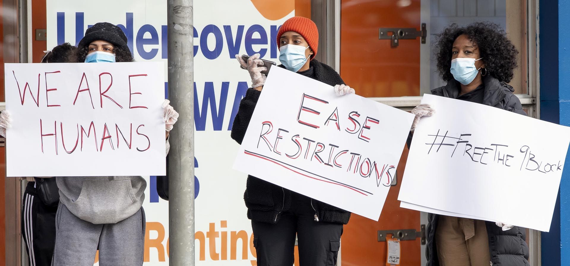 Un grupo de mujeres sostienen pancartas afuera de los apartamentos de la comisión de vivienda bajo encierro en Melbourne, Australia. La variante del coronavirus se extendió por Australia a pesar de su alta tasa de vacunación y las estrictas políticas fronterizas que mantuvieron al país aislado del mundo durante casi dos años.