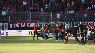 Salomón (en el fondo) deja la cancha en el carrito. Noguera (en primer plano), listo para entrar en Newells