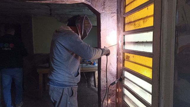 Un operario bloquea con una soldadora una de las aberturas de la casa de Cabal al 900 bis