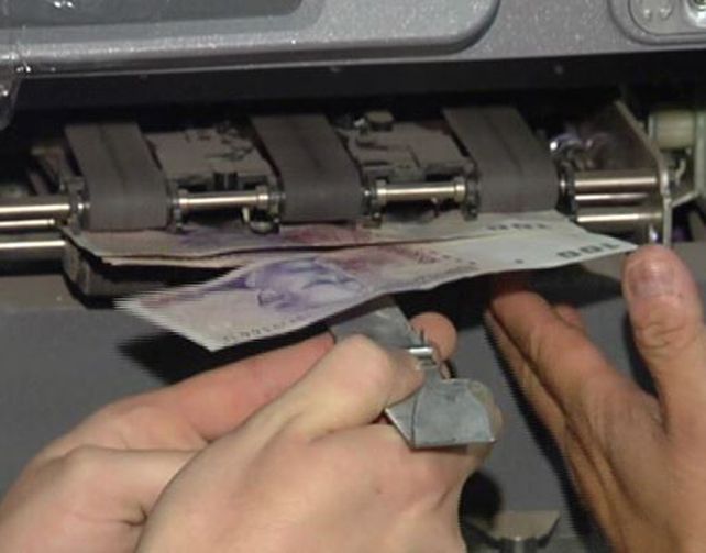 La hoja de metal traba la ranura por donde se expende el dinero. Eso usaban para concretar el ardid.