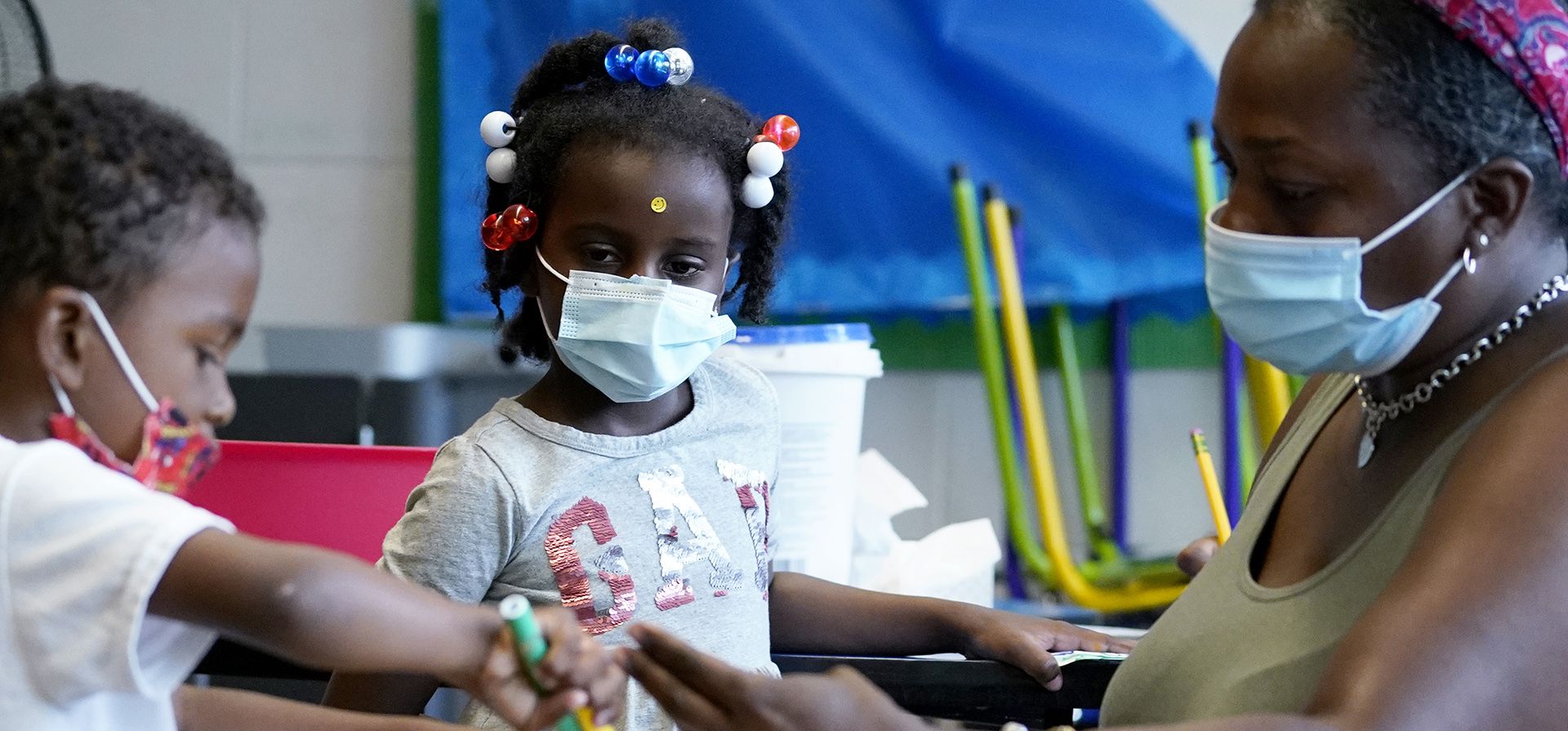 Una maestra revisa el trabajo de arte durante una clase en la escuela primaria Chalmers en Chicago. Las escuelas de las grandes ciudades de Estados Unidos están disminuyendo, y cada vez más de sus escuelas atienden a un pequeño número de estudiantes. Esas escuelas pequeñas son costosas de mantener y, a menudo, aún no pueden ofrecer todo lo que los estudiantes necesitan.