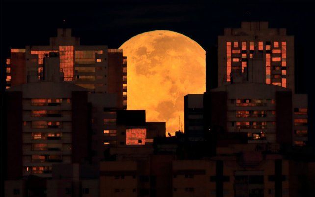 La luna está parcialmente cubierta por edificios en Brasilia, Brasil, al comienzo de un eclipse lunar total la madrugada del miércoles 26 de mayo de 2021. El eclipse del miércoles es el primero en más de dos años y coincide con una superluna.