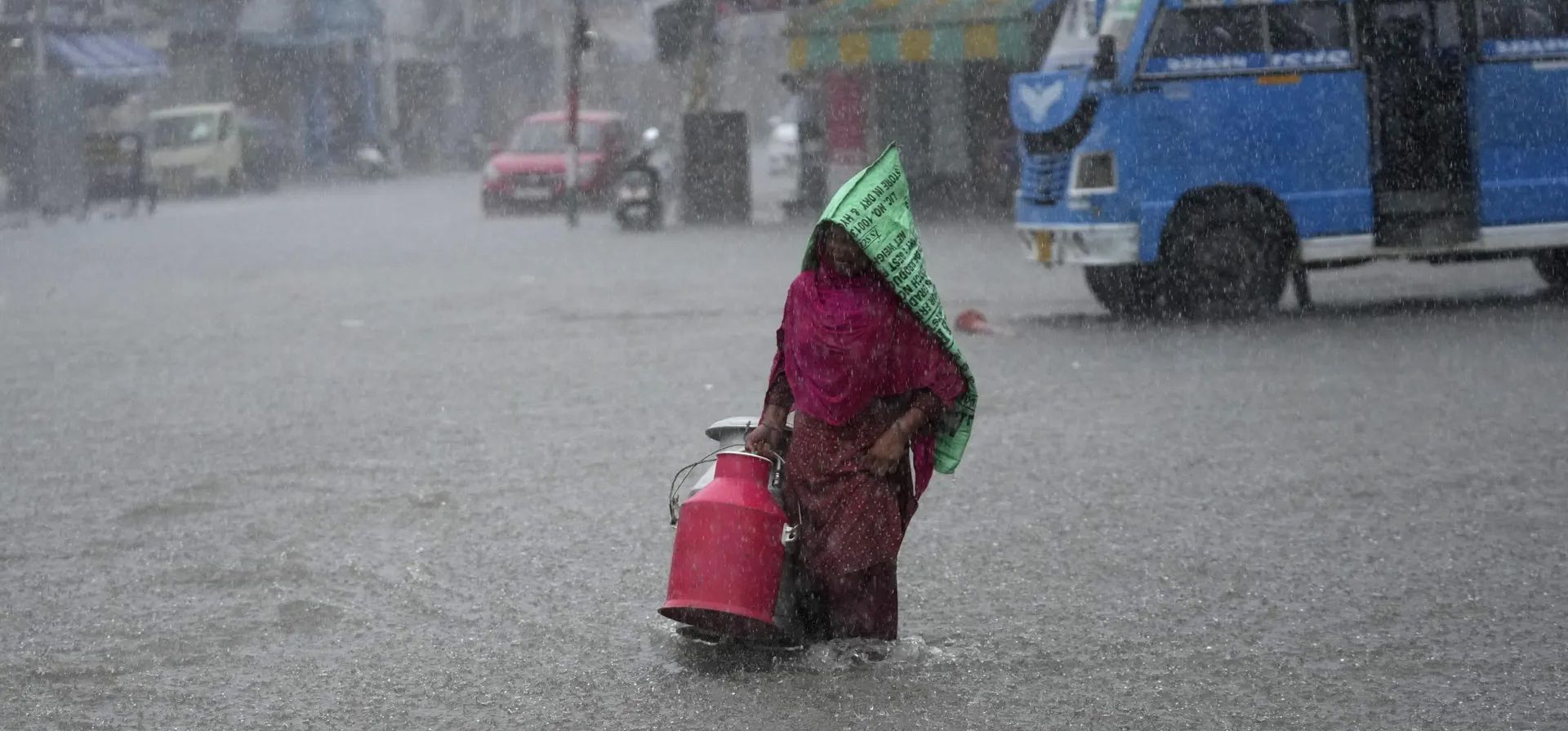 Una mujer atraviesa una calle anegada durante las fuertes lluvias. La temporada de monzones de la India se extiende de junio a septiembre, Jammu, India. Fotografía: Channi Anand/AP