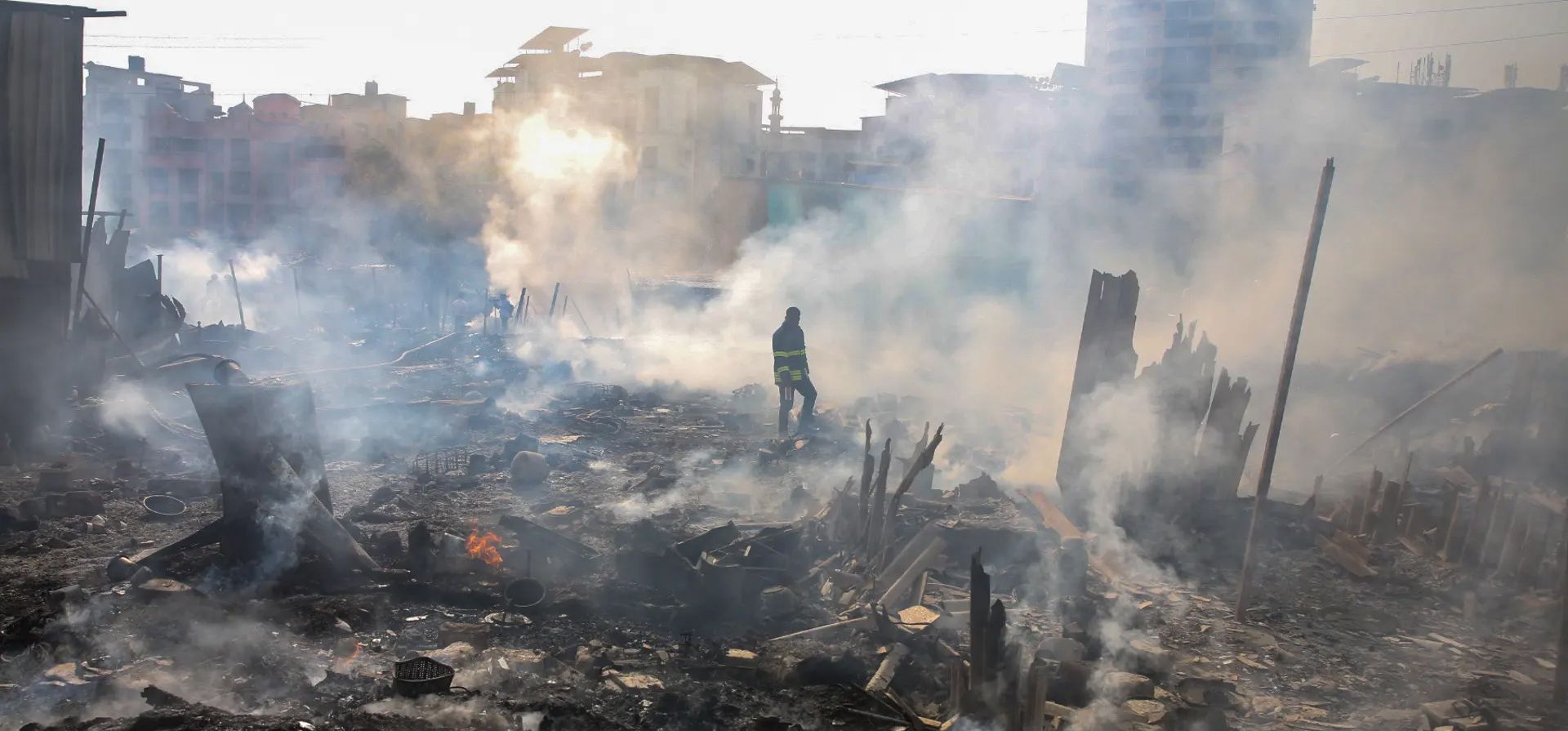 Un bombero se encuentra en medio del humo después de un incendio en el barrio pobre de Azad Nagar. Las autoridades dijeron que una persona murió y cinco resultaron heridas después de que se iniciara un incendio a partir de desechos arrojados cerca, Mumbai, India. Fotografía: Divyakant Solanki/EPA Un bombero se encuentra en medio del humo después de un incendio en el barrio pobre de Azad Nagar. Las autoridades dijeron que una persona murió y cinco resultaron heridas después de que se iniciara un incendio a partir de desechos arrojados cerca, Mumbai, India. Fotografía: Divyakant Solanki/EPA