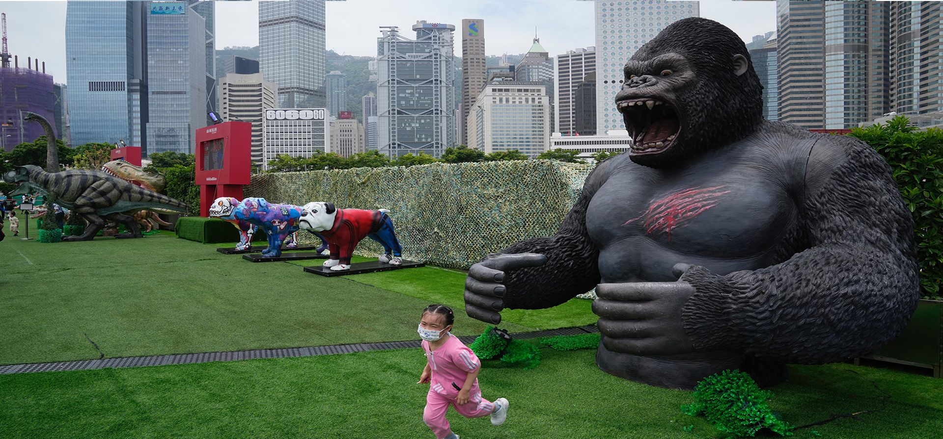 Una niña huye de una réplica de un gorila en el parque Noah