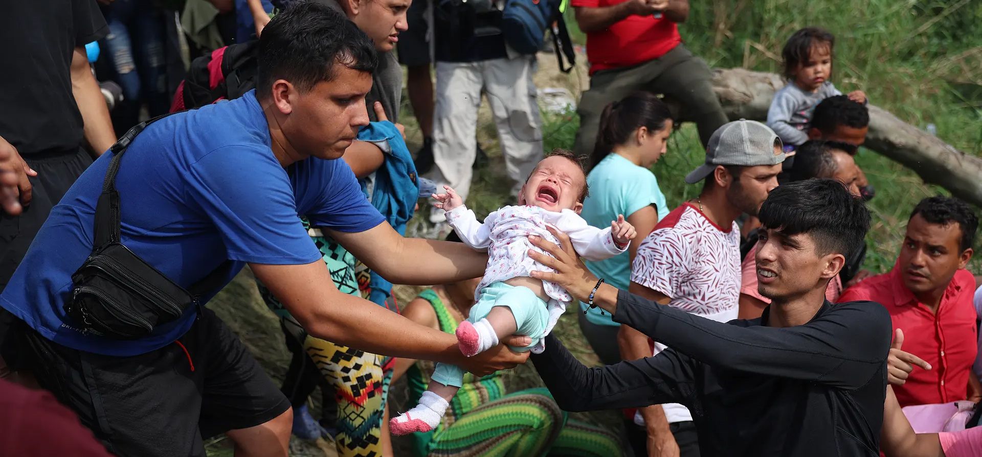 Matamoros, México. Un bebé se pasa entre las personas mientras se dirigen hacia el Río Grande mientras cruzan para ingresar a los Estados Unidos. Fotografía: Joe Raedle/Getty Images