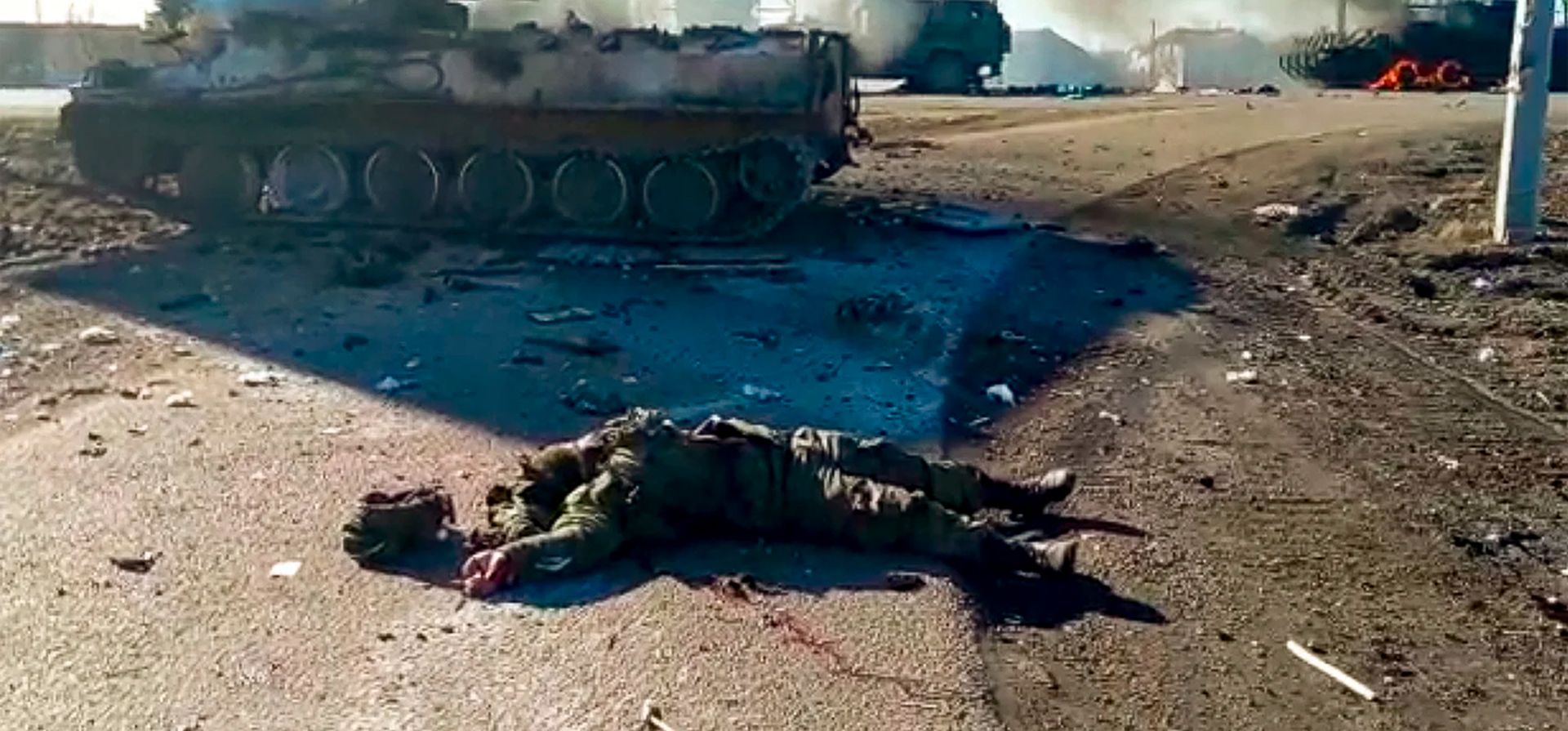 Captura de un video publicado por el Servicio de Prensa del Departamento de Policía de Ucrania, el cuerpo de un soldado muerto yace en el suelo junto a vehículos militares destrozados después de un ataque en el este de Ucrania. (Servicio de Prensa del Departamento de Policía de Ucrania vía AP)