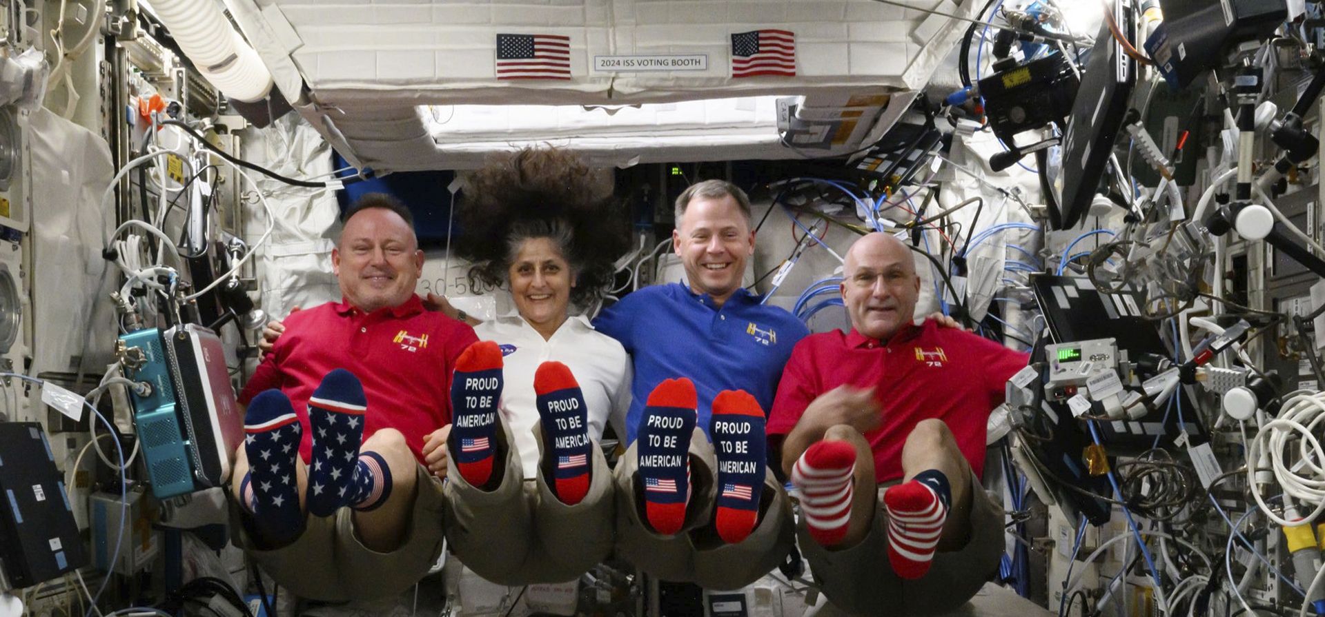 Foto proporcionada por la NASA, de izquierda a derecha, los astronautas Butch Wilmore, Suni Williams, Nick Hague y Don Pettit muestran sus calcetines con la bandera de Estados Unidos en la Estación Espacial Internacional, el día de la elección, el martes 5 de noviembre de 2024. (NASA vía AP)  