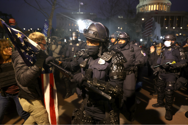 tensión. Policías antidisturbios se enfrentan a los manifestantes concentrados en las afueras del Capitolio una vez producido el desalojo.
