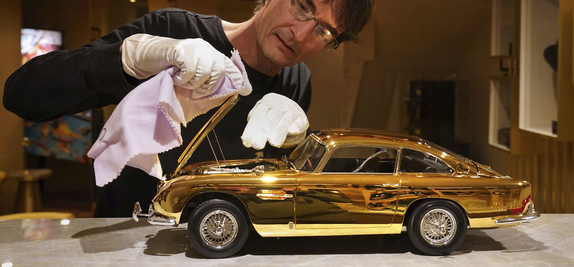 Un modelo bañado en oro de 24 quilates del Aston Martin DB5 Goldfinger de James Bond, uno de los siete fabricados en escala 1:8 con calidad de museo por los fabricantes británicos de kits de coches Agora Models, se exhibe en Burlington Arcade, Londres, el jueves 19 de septiembre de 2024,  (Jonathan Brady/PA vía AP)