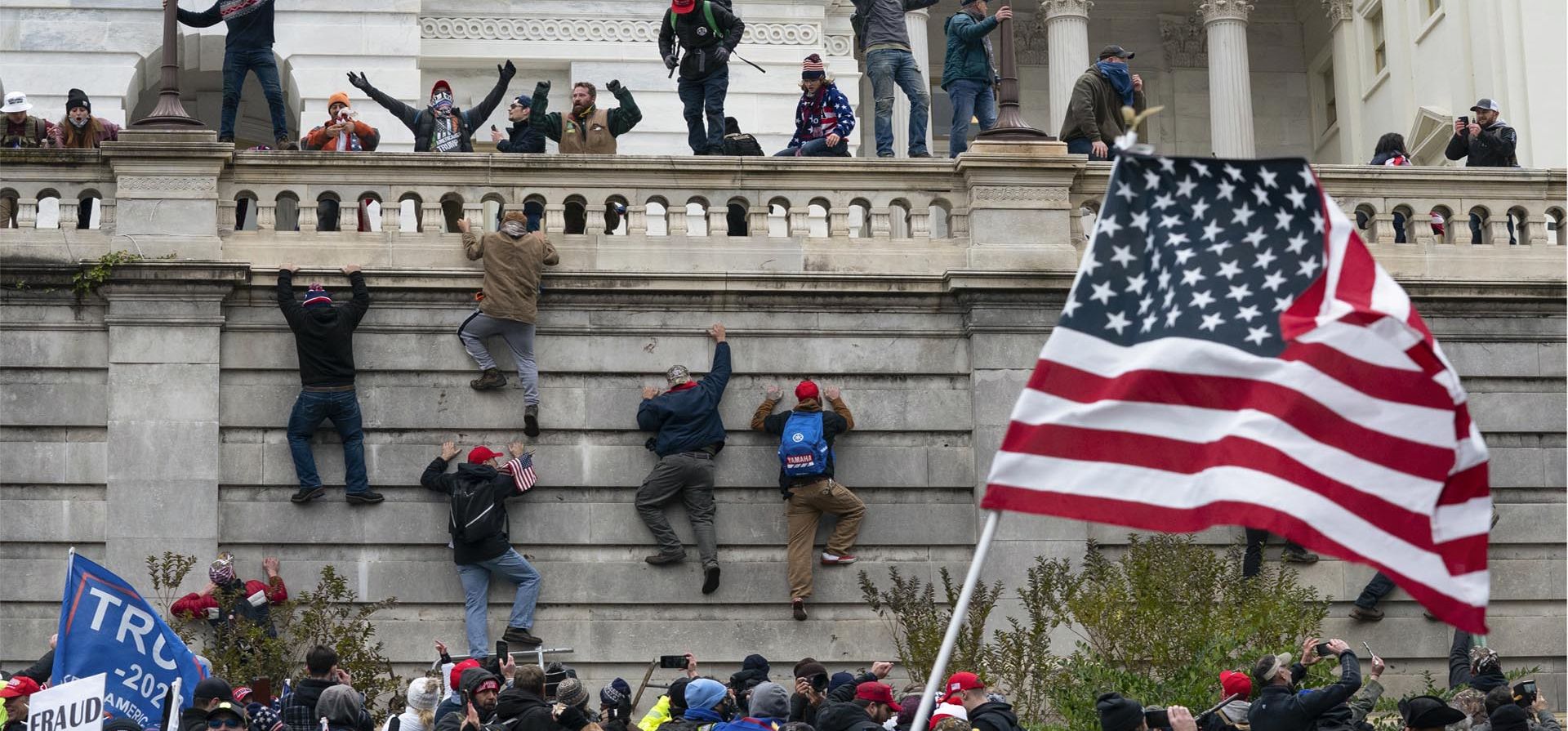 Manifestantes escalan un muro en el Capitolio de los Estados Unidos el 6 de enero de 2021 en Washington.