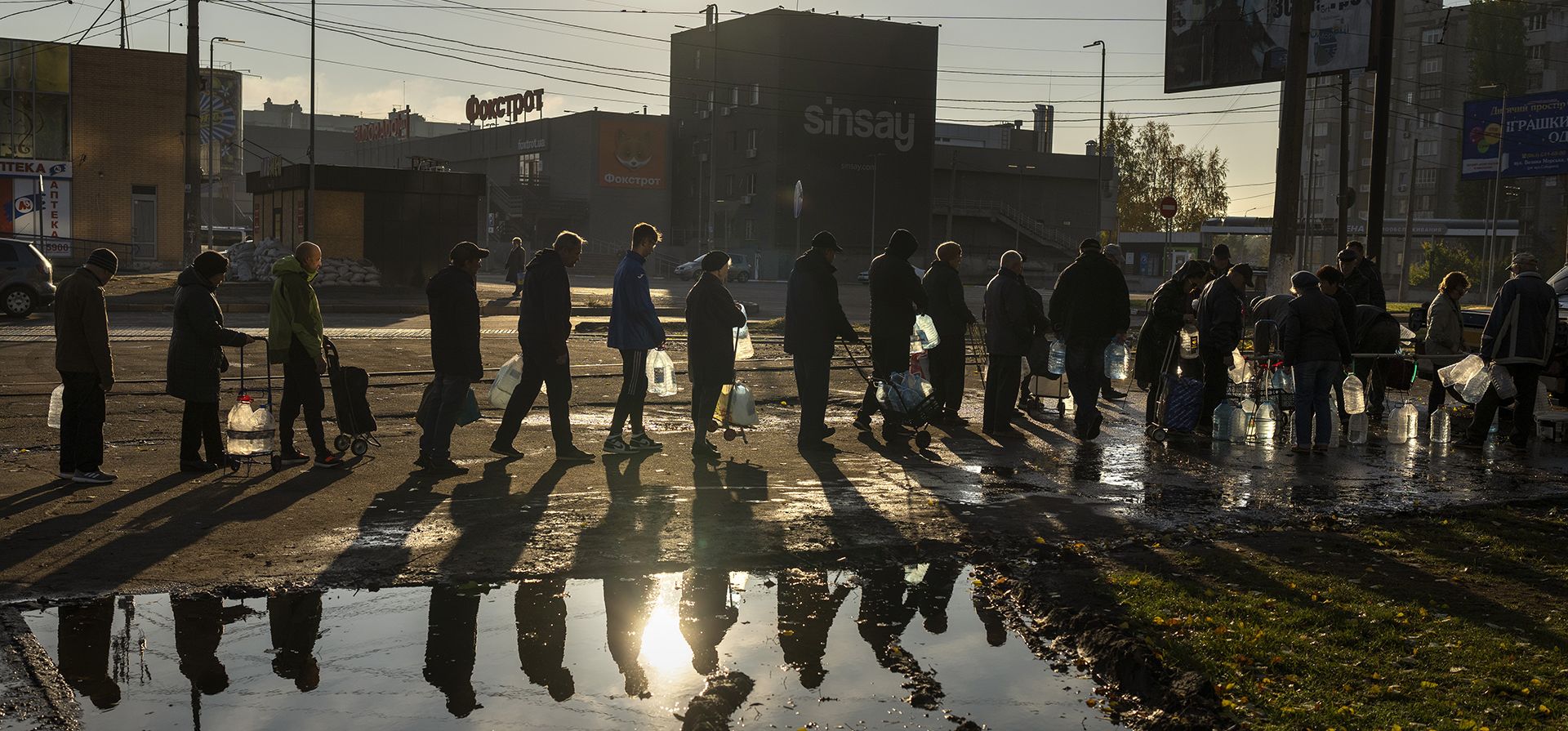 Personas hacen cola con botellas de plástico para rellenar de agua potable de un tanque en el centro de Mykolaiv, el lunes 24 de octubre de 2022. Desde mediados de abril, los ciudadanos de Mykolaiv, con una población de antes de la guerra de medio millón de personas, han vivido sin suministro centralizado de agua potable. Las fuerzas rusas cortaron la tubería a través de la cual la ciudad recibió agua potable durante los últimos 40 años.