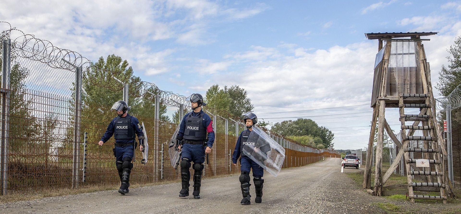 Policías operativos caminan a lo largo de la ruta de servicio de la frontera de Hungría con Serbia cerca de Roszke, en el sur de Hungría, el miércoles 28 de septiembre de 2022. A principios de este mes, los primeros quinientos reclutas capacitados fueron comisionados para servir en la patrulla fronteriza recién formada del país. Su tarea principal es proteger las fronteras estatales de la invasión de inmigrantes ilegales.