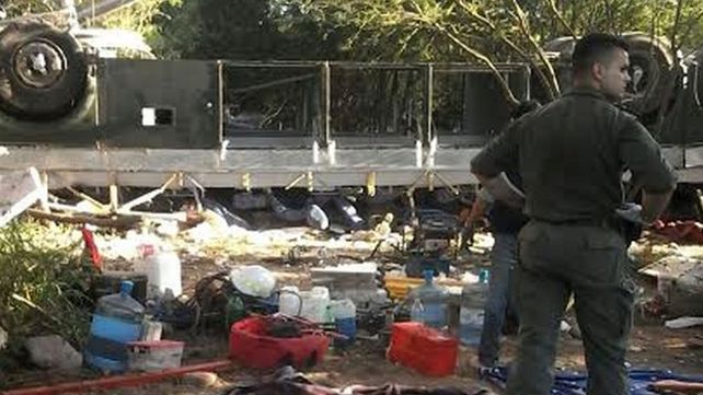Un gendarme observa los restos del ómnibus donde viajaban sus colegas. (Foto: Télam)