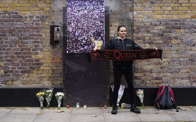 Una fan sostiene una bufanda de la banda de rock británica Queen