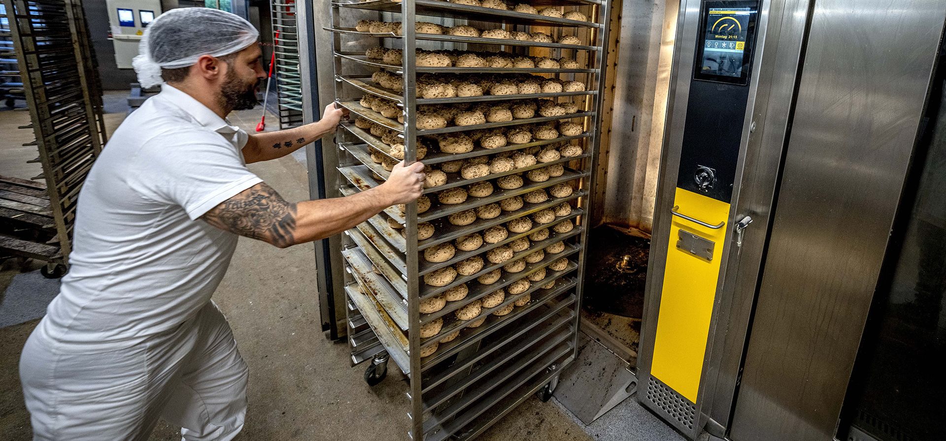 Un empleado empuja un carro con panecillos en uno de los hornos calentados a gas en la planta de producción en Neu Isenburg, Alemania, el lunes 19 de septiembre de 2022. Andreas Schmitt, jefe del gremio local de panaderos, dijo que algunas panaderías pequeñas están contemplando darse por vencidas debido a la crisis energética.