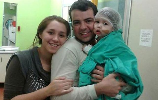 Renzo con sus padres. El niño correntino superó una cirugía de 14 horas.