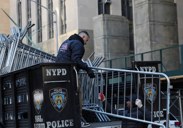 Policías de Nueva York descargan vallas metálicas delante de la sede de la Fiscalía de Manhattan.