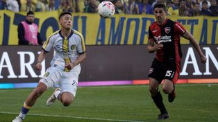 Alejo Veliz y Gustavo Velázquez luchan por el balón en el último clásico rosarino, disputado en el Gigante de Arroyito.