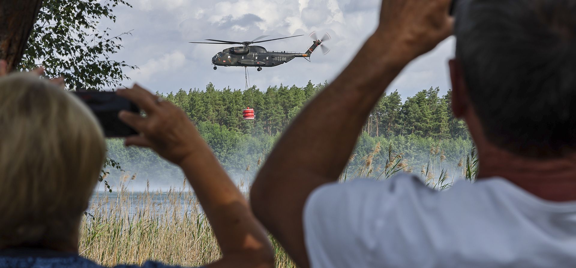 Un helicóptero bombero Bell CH-53 del ejército alemán Bundeswehr carga agua de un mar en Falkenberg, Alemania. Los bomberos en Brandeburgo continúan combatiendo un gran incendio forestal en el distrito de Elbe-Elster.