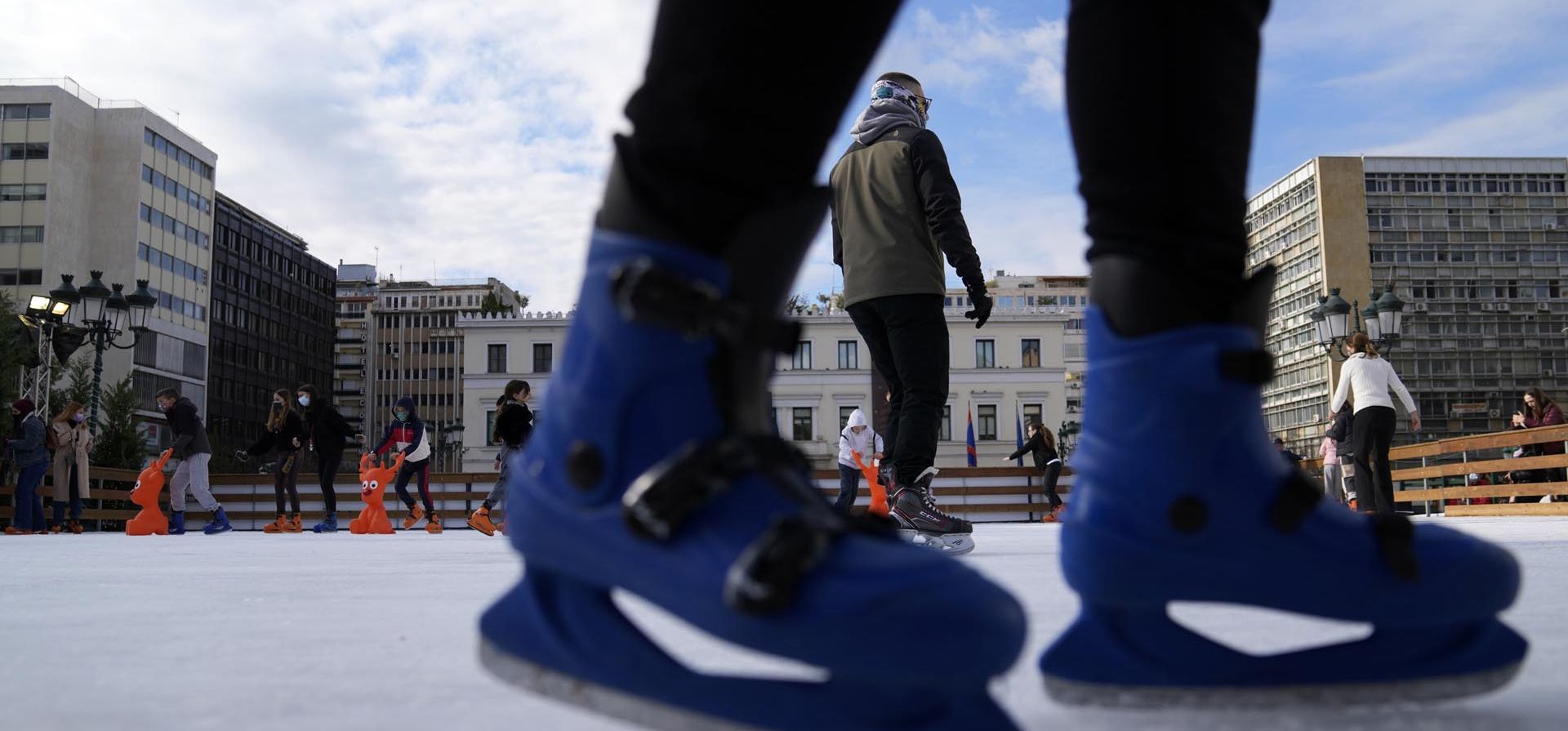 Personas patinan sobre hielo en una pista frente al Ayuntamiento de Atenas, Grecia, el jueves 23 de diciembre de 2021. Los conciertos de Navidad y otros eventos han sido cancelados en Grecia como parte de nuevas restricciones que incluyen la obligción de cubrebocas para lugares abiertos y todas las áreas públicas. Foto: AP