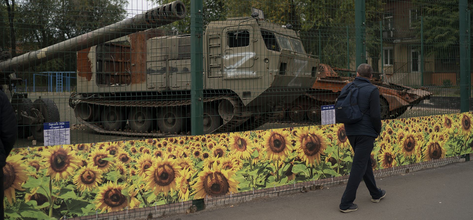 Un hombre pasa frente a una exhibición de vehículos militares rusos destruidos durante el