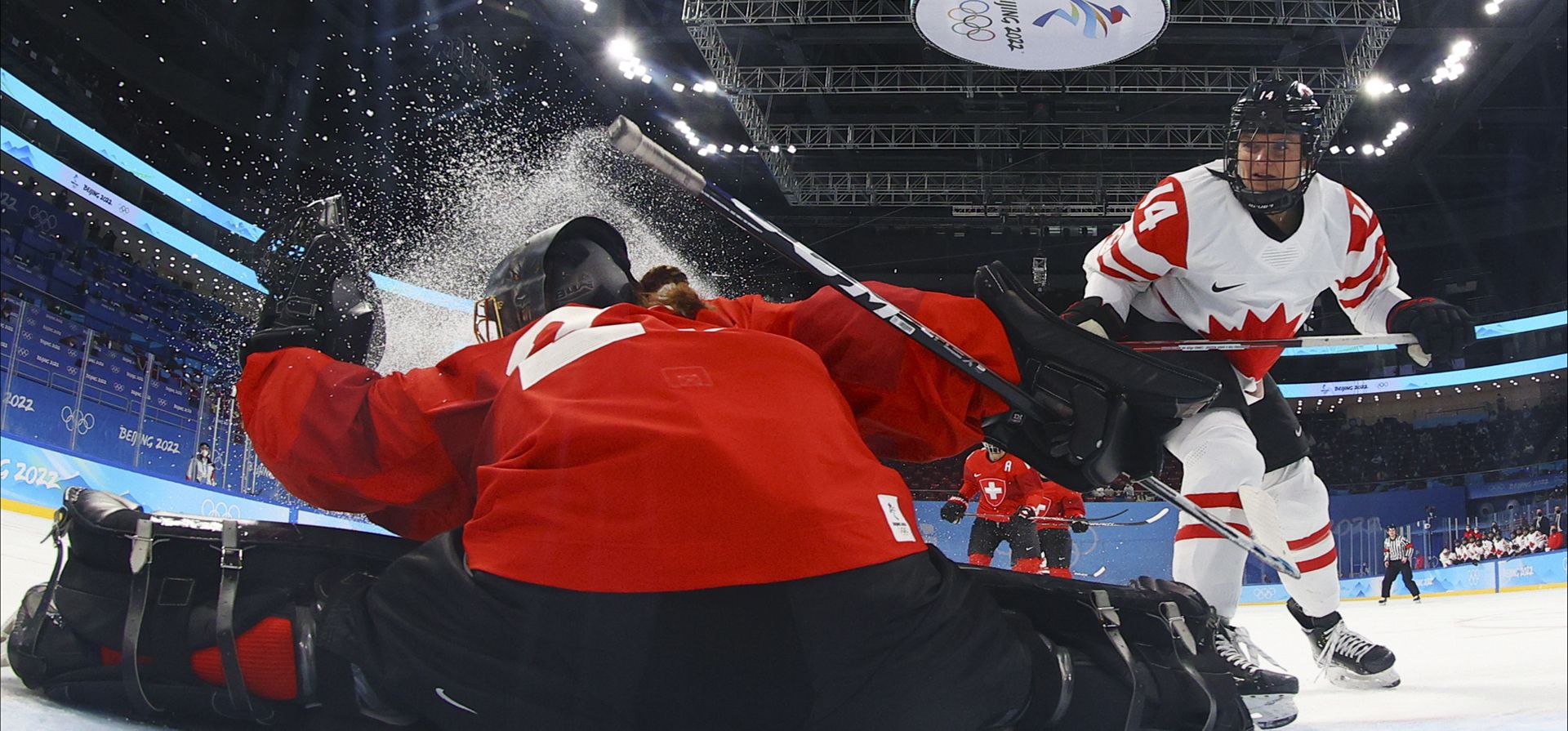 La portera suiza Saskia Maurer (29) hace una parada frente a la canadiense Renata Fast (14) durante un partido de hockey femenino en la semifinal de los Juegos Olímpicos de Invierno de 2022, el lunes 14 de febrero de 2022 en Beijing.