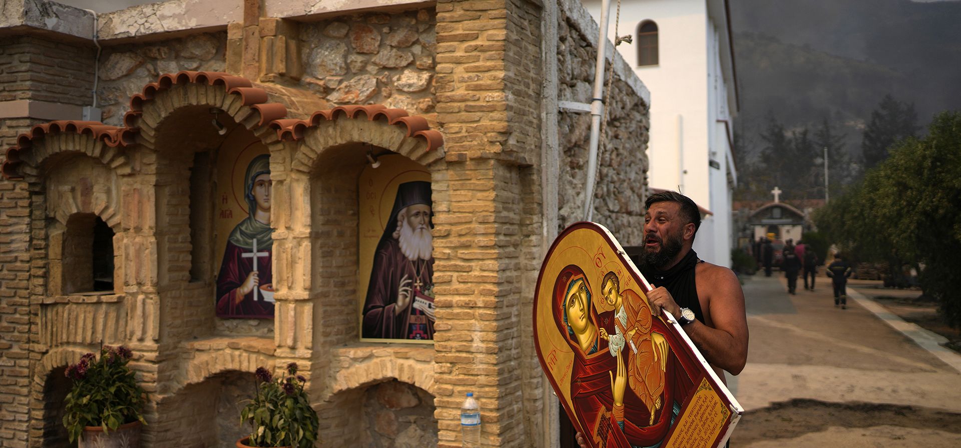 Un hombre lleva un ícono de Santa María con Jesús para salvarlo de un incendio forestal en el monasterio ortodoxo cristiano Agia Paraskevi en Acharnes, un suburbio del norte de Atenas, Grecia, el miércoles 23 de agosto de 2023. Aviones que arrojan agua de varios países europeos se unieron a cientos de bomberos que luchan contra los incendios forestales que se han extendido durante días en Grecia y que han dejado 20 muertos. (Foto AP/Thanassis Stavrakis) Un hombre lleva un ícono de Santa María con Jesús para salvarlo de un incendio forestal en el monasterio ortodoxo cristiano Agia Paraskevi en Acharnes, un suburbio del norte de Atenas, Grecia, el miércoles 23 de agosto de 2023. Aviones que arrojan agua de varios países europeos se unieron a cientos de bomberos que luchan contra los incendios forestales que se han extendido durante días en Grecia y que han dejado 20 muertos. (Foto AP/Thanassis Stavrakis)
