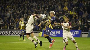 El nuevo centrodelantero de Central Enzo Copetti se esfuerza entre la marca de los jugadores de Lanús Ezequiel Muñoz y el excanalla Nery Domínguez.