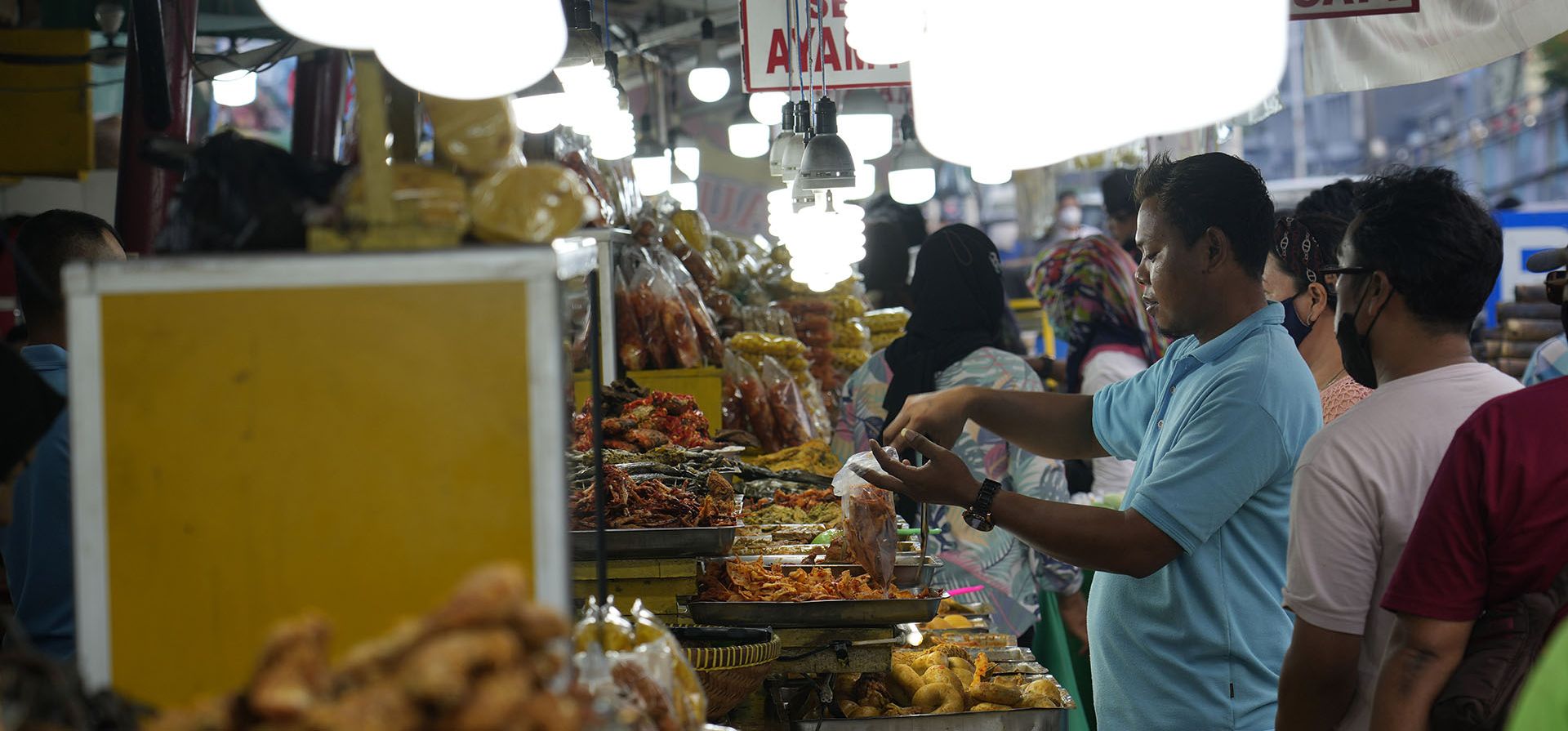 Un trabajador sirve comidas iftar a los clientes para romper el ayuno en un patio de comidas al borde de la carretera durante el Ramadán en Yakarta, Indonesia, el miércoles 13 de abril de 2022. Musulmanes de todo el mundo transitan el Ramadán, el mes más sagrado del calendario islámico, donde se abstienen de comer, beber, fumar y tener sexo desde el amanecer hasta el anochecer.