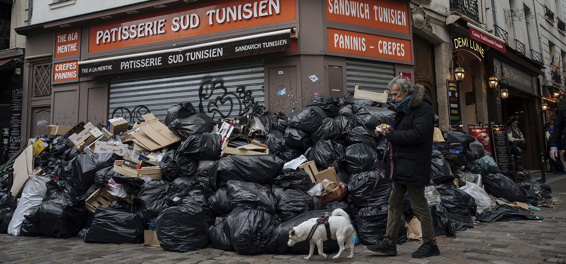 Un hombre pasa junto a montones de basura en París, el 13 de marzo de 2023. Los recolectores de basura de París levantaron el aviso de huelga que amenazaba con dejar la capital francesa bajo montones de basura durante los Juegos Olímpicos después de llegar a un acuerdo que mejorará su salario.  (Foto AP/Lewis Joly, archivo)