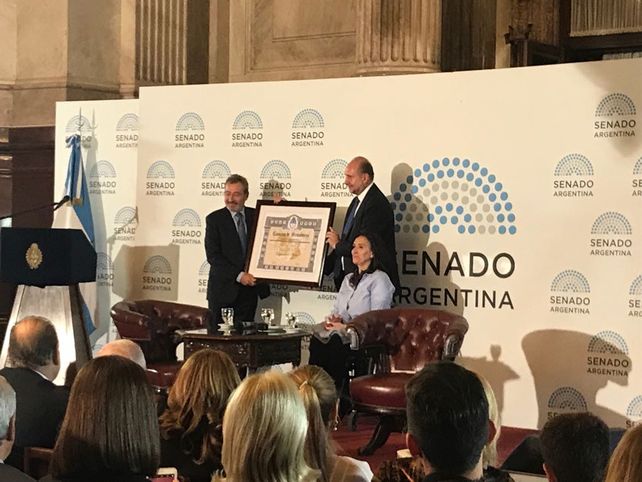 Vila recibe la distinción de manos de Perotti.