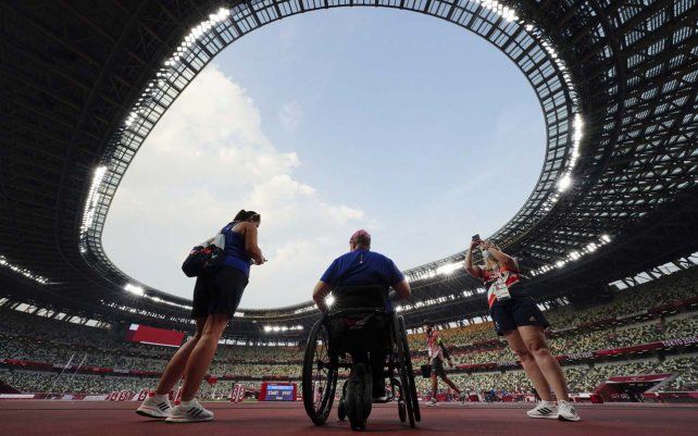 Miembros del equipo de Gran Bretaña contemplan el Estadio Olímpico, sede de las competencias atléticas de los Juegos Paralímpicos de Tokio 2020, el jueves 26 de agosto de 2021 en Tokio, Japón.