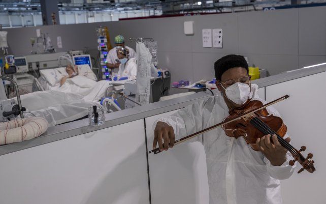 Un músico toca el violín durante un mini concierto de Mozart para pacientes con COVID-19 organizado por la Fundación Músicos por la Salud en la unidad de cuidados intensivos del Hospital Enfermera Isabel Zendal en Madrid, España.
