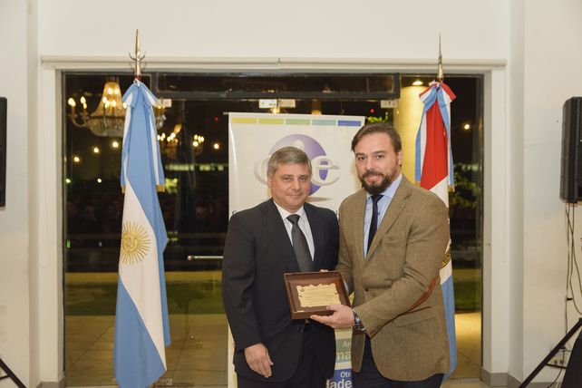 El Dr. Juan Pablo Gutiérrez recibe la placa homenaje de manos del Ing. Raúl Bustaber