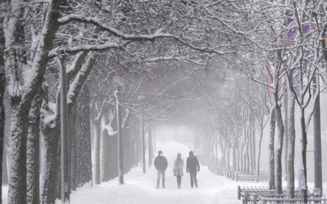 Los peatones caminan por una acera cubierta de nieve en el Grant Park de Chicago, se espera que la tormenta invernal arroje casi un pie de nieve en el área metropolitana de Chicago.