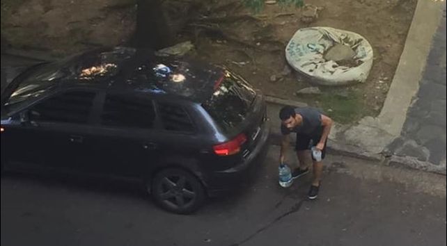 El muchacho bajando los bidones del auto.&nbsp;