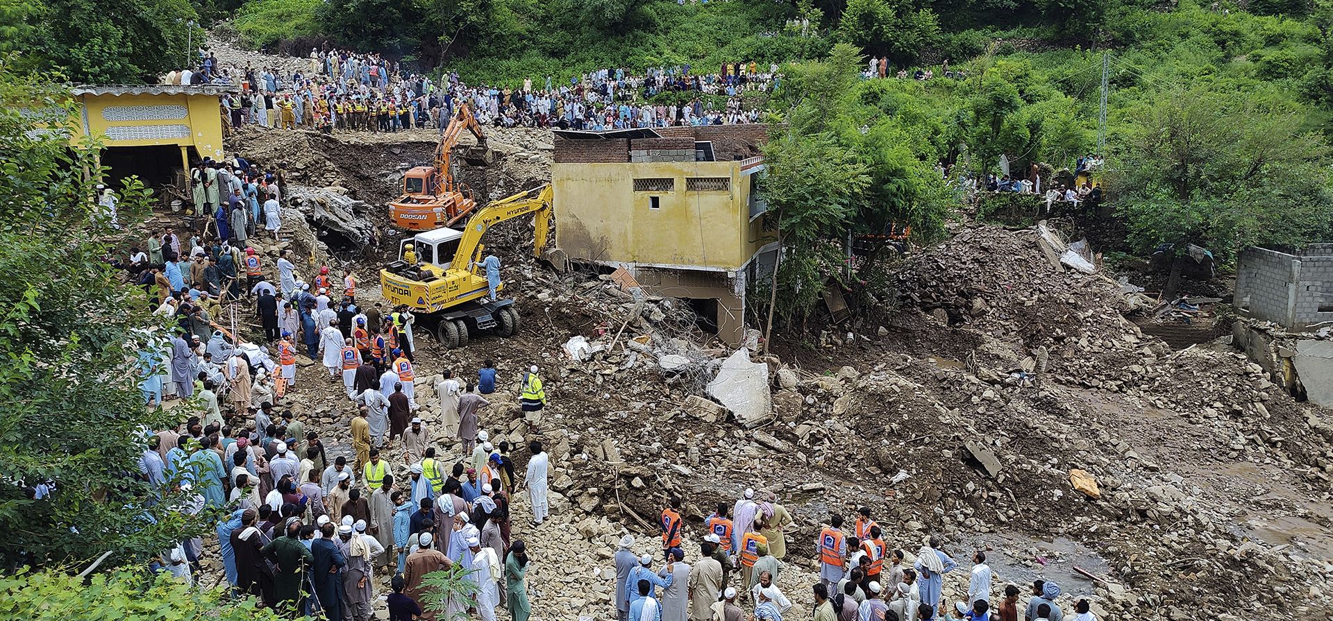 Residentes locales observan a los rescatistas buscar víctimas entre los escombros de las casas dañadas tras las inundaciones repentinas del lunes en la aldea de Dalori en Swabi, un distrito de la provincia pakistaní de Khyber Pakhtunkhwa, el martes 19 de agosto de 2025. (Foto AP/Ziaud Din) Residentes locales observan a los rescatistas buscar víctimas entre los escombros de las casas dañadas tras las inundaciones repentinas del lunes en la aldea de Dalori en Swabi, un distrito de la provincia pakistaní de Khyber Pakhtunkhwa, el martes 19 de agosto de 2025. (Foto AP/Ziaud Din)