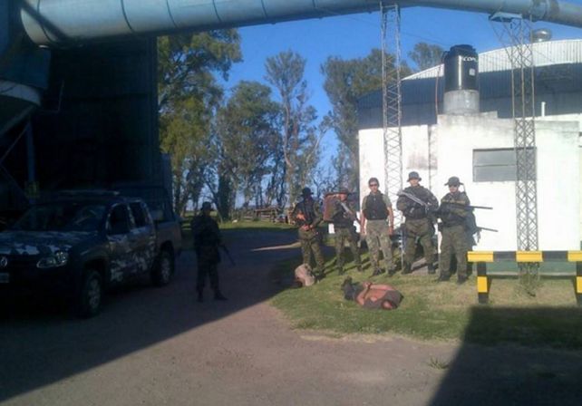 Los agentes de la Tropa de Operaciones Especiales de la policía santafesina junto a los dos detenidos en el interior de la arrocera