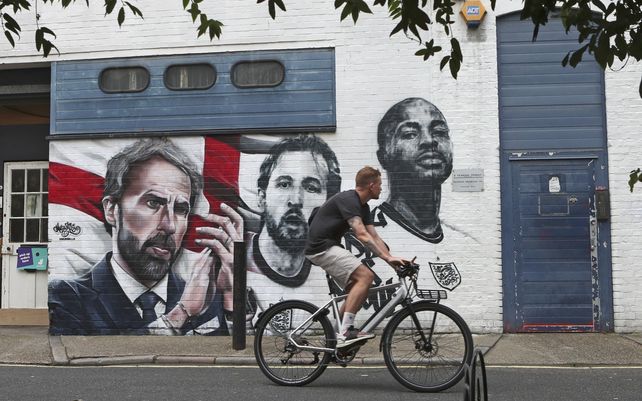 Un ciclista pasa junto a un mural que representa al entrenador de Inglaterra Gareth Southgate