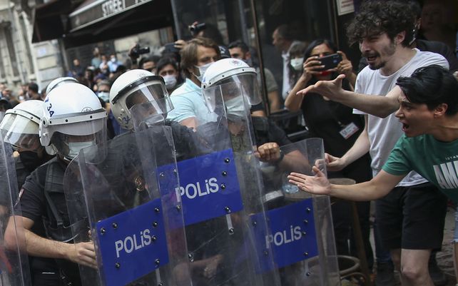 Activistas confrontan a los agentes de policía antidisturbios que se movilizan para dispersar a las multitudes que intentaron organizar un evento de orgullo en el centro de Estambul.
