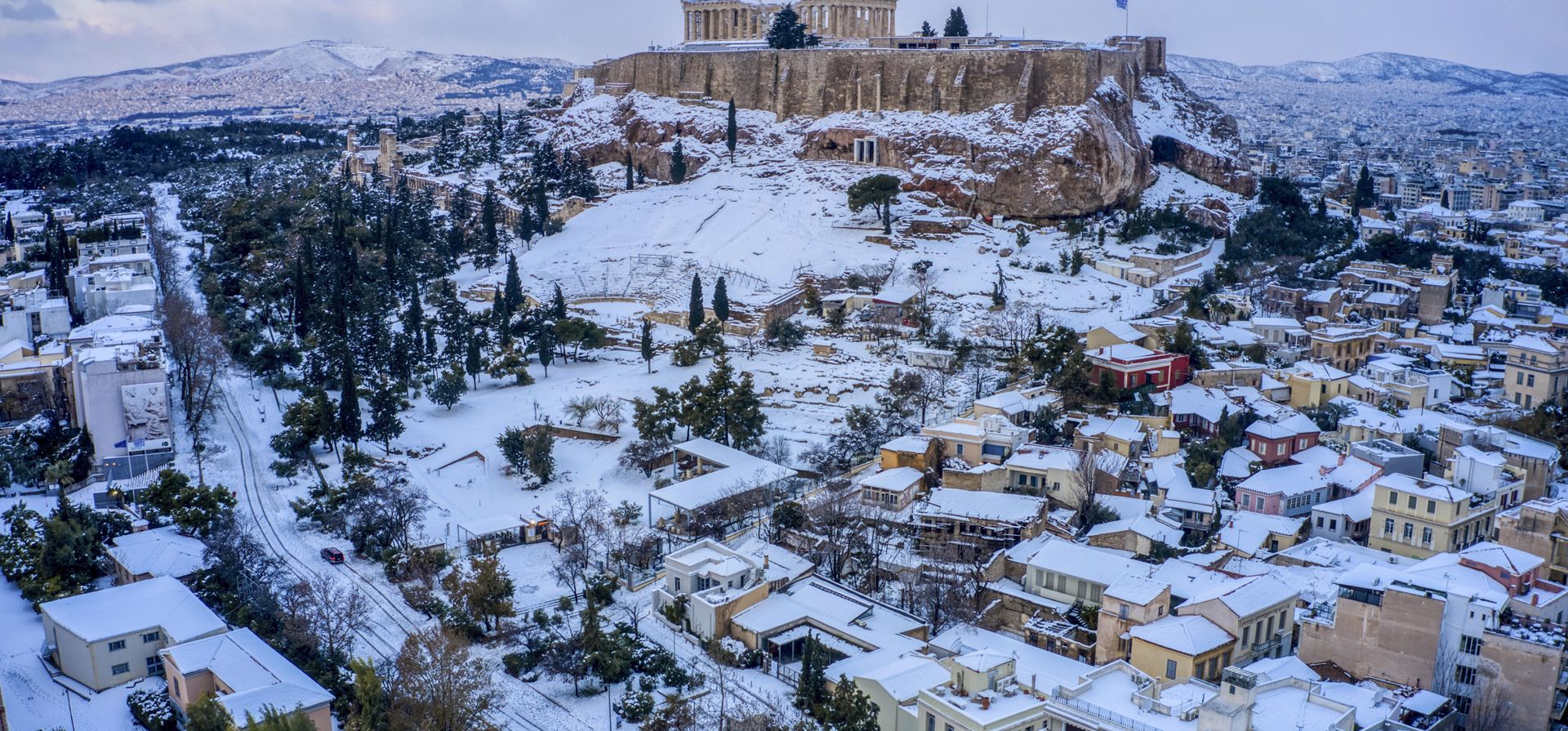 La ciudad de Atenas con la antigua colina de la Acrópolis está cubierta de nieve después de una fuerte nevada. Una tormenta de nieve de gravedad interrumpió el tráfico aéreo y por carretera el lunes en la capital griega de Atenas y en la vecina ciudad más grande de Turquía, Estambul.