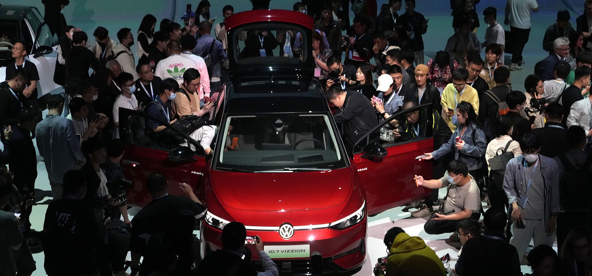 El público observa de cerca el Volkswagen ID.7 Vizzion, un nuevo sedán eléctrico insignia durante un estreno mundial en la víspera de la feria Auto Shanghai 2023 en Shanghái, China, el lunes 17 de abril de 2023. (Foto AP/Ng Han Guan)