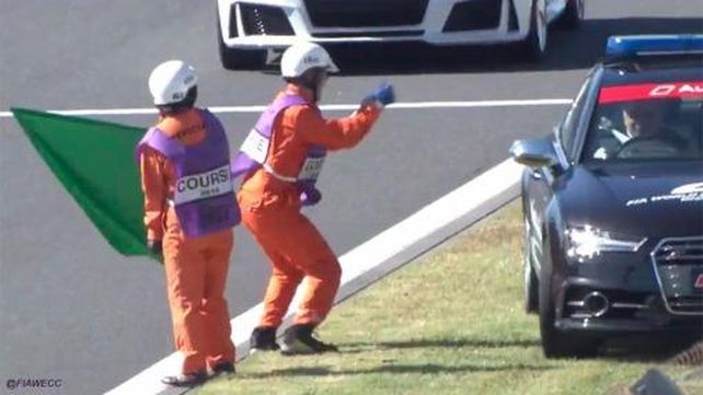 Un comisario de pista bailando en un autódromo