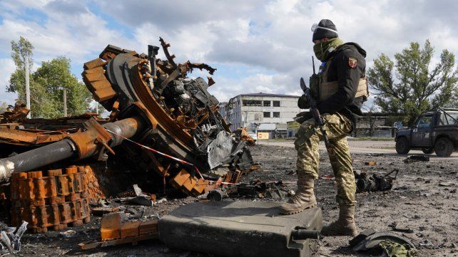 Un soldado ucraniano posa junto a los restos de un tanque ruso.