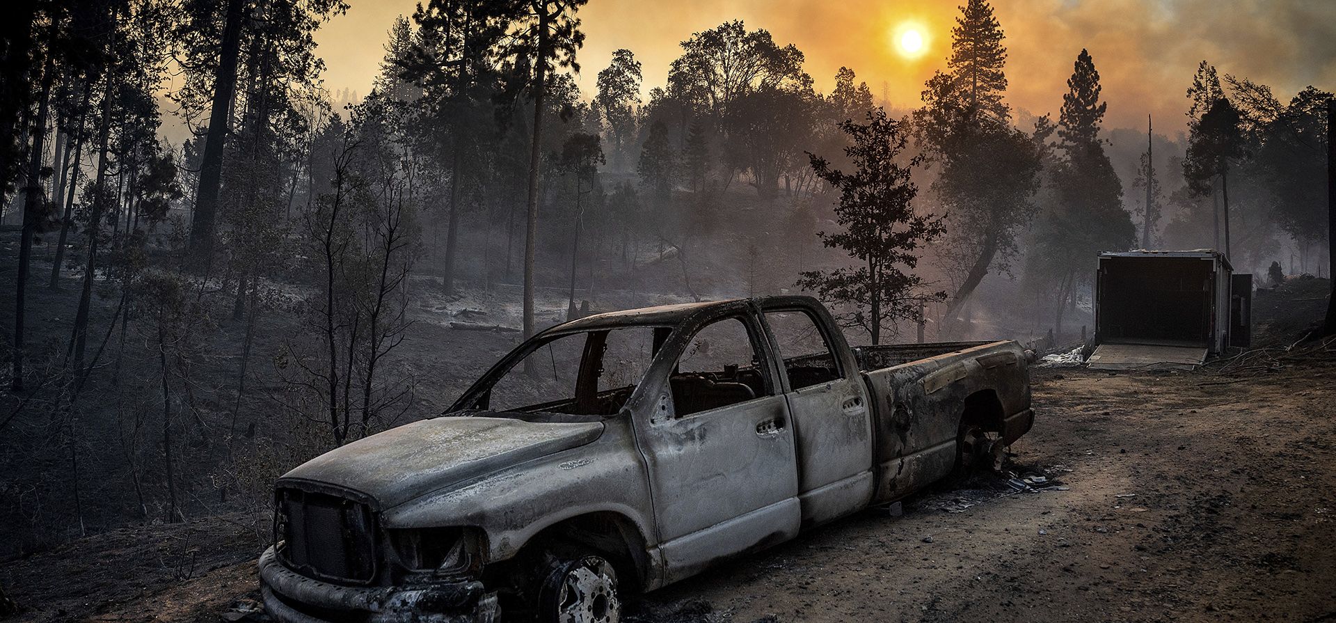 El Oak Fire arde detrás de una camioneta quemada en la comunidad de Jerseydale del condado de Mariposa, California, la madrugada del domingo 24 de julio de 2022.